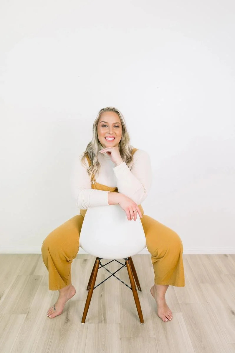 Dr. Jennifer Gordon seated on a chair for a portrait at Taproot Chiropractic