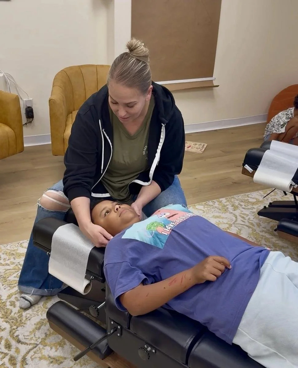 Dr. Jennifer Gordon gently supporting a boy's head and neck on a treatment table