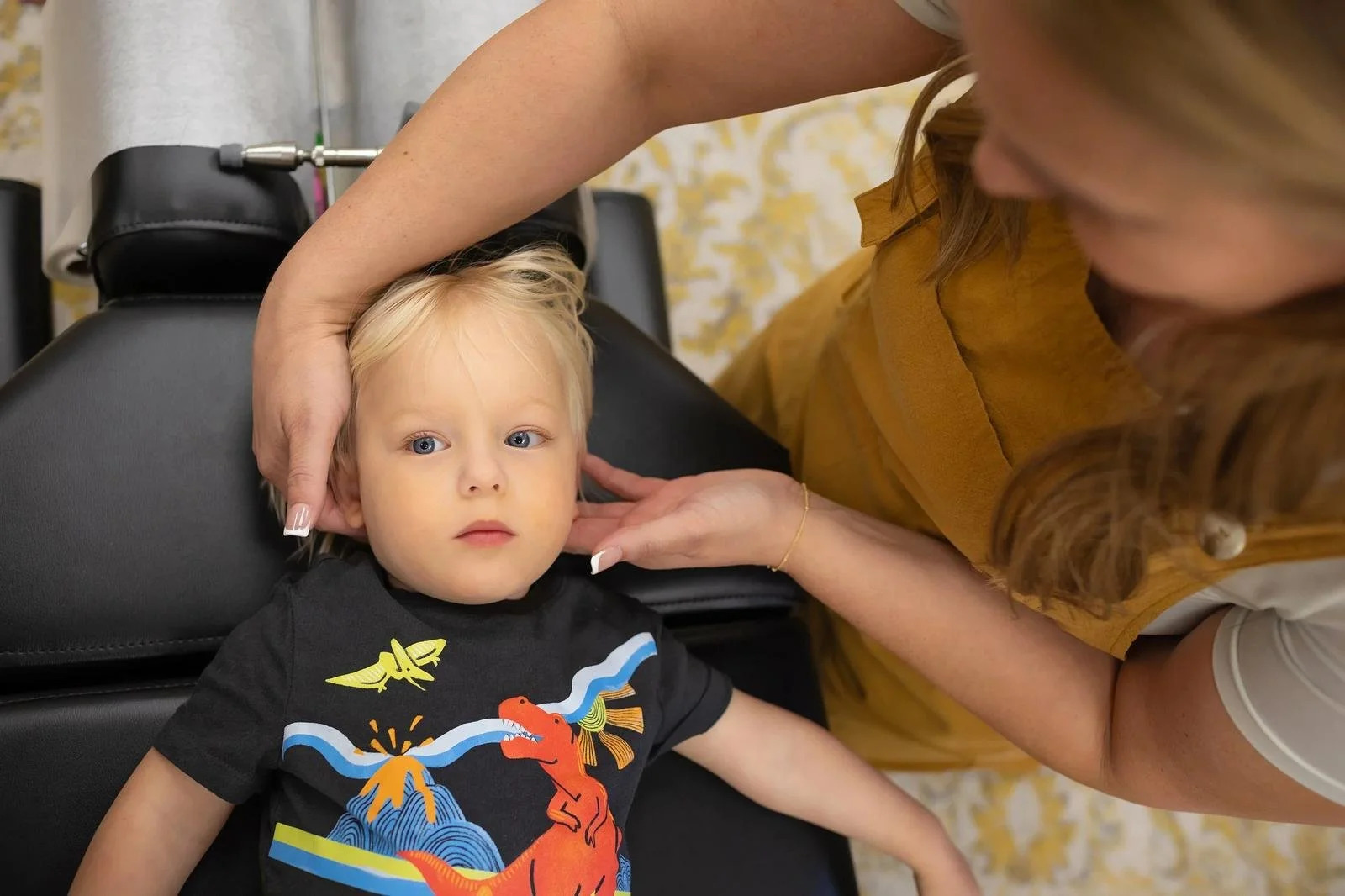 Dr. Jennifer Gordon gently supporting a young child's head and neck during assessment