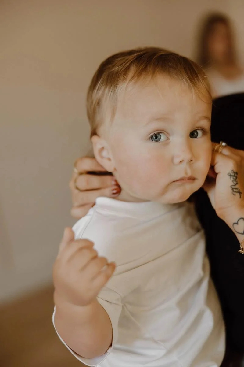 Chiropractor gently supporting a toddler's neck during assessment