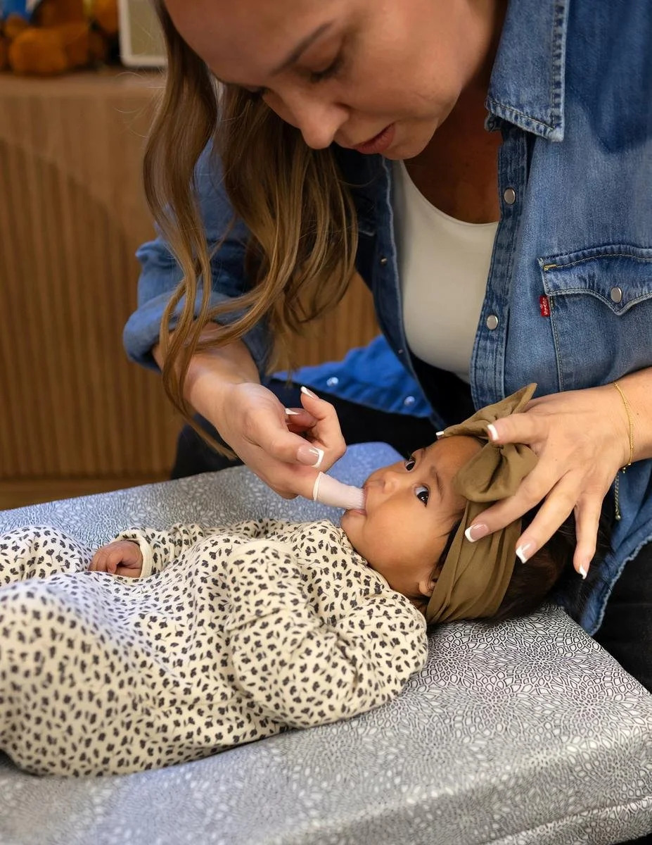 Dr. Jennifer Gordon performing a gentle oral assessment on an infant